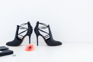 Heels, a flower and a purse arranged on a surface