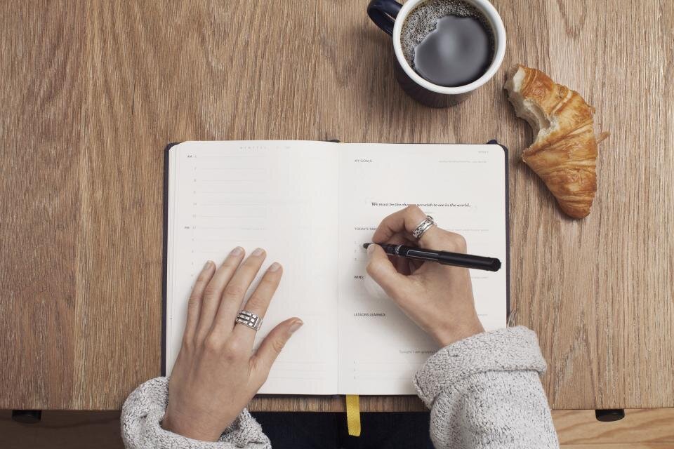 An open notebook and pen on a desk